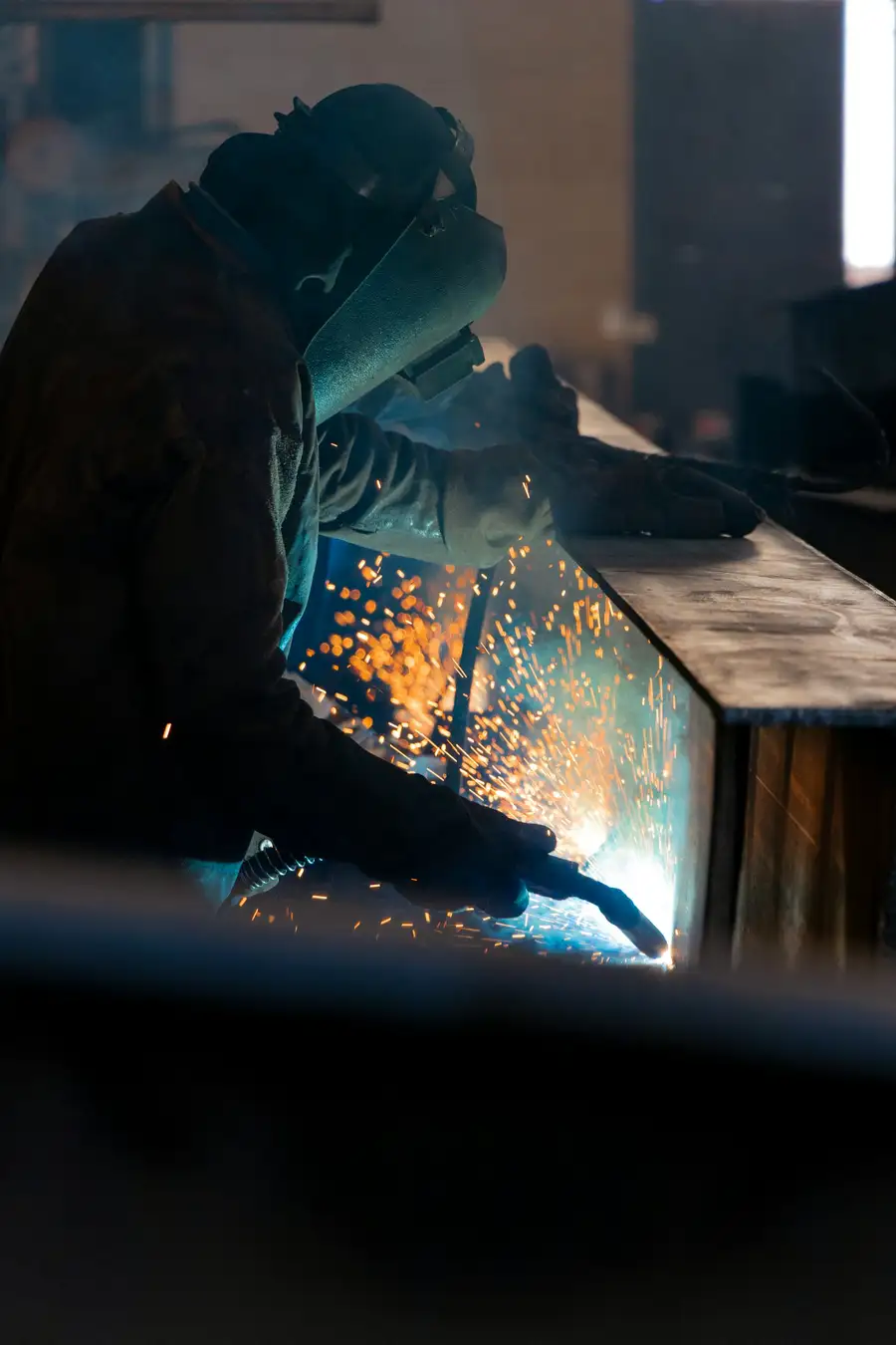 A welder at work in a manufacturing plant